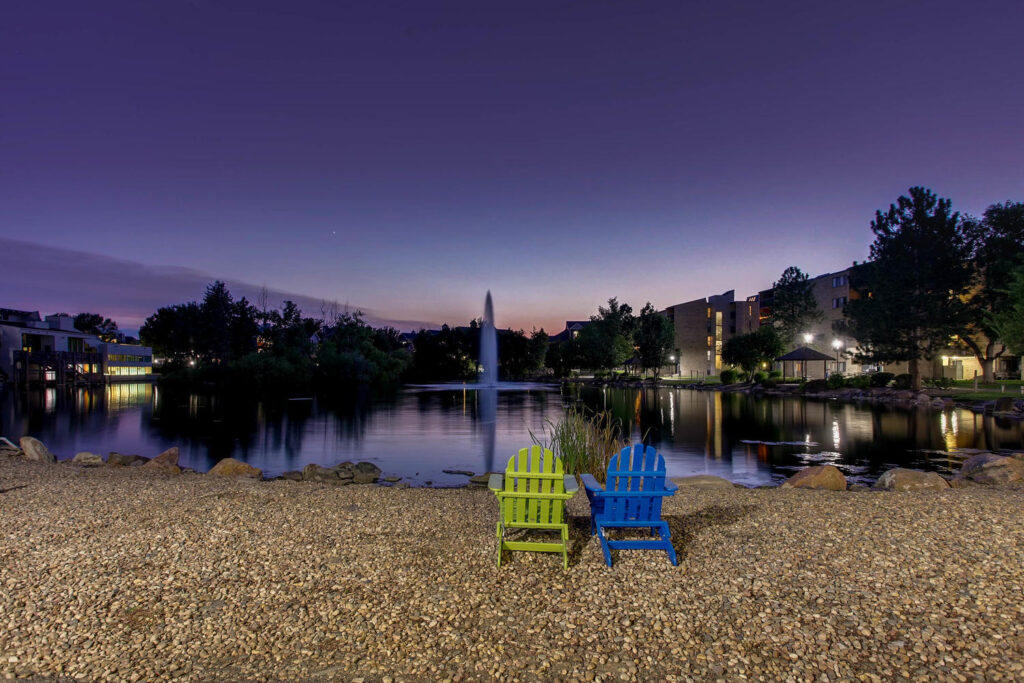 Two chairs on the edge of the lake facing the water