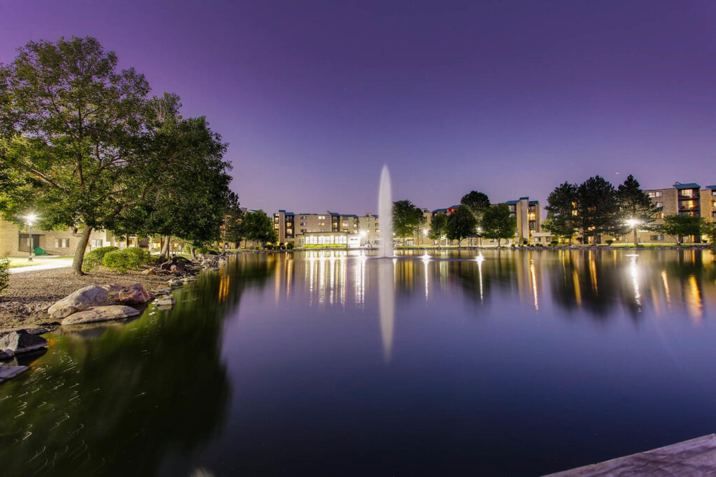 Lake with large trees and a fountain near Lakeview Towers at Belmar