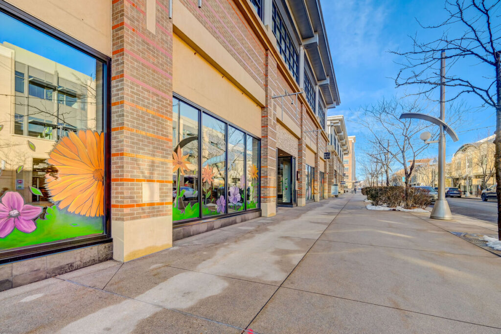 Outdoor shopping district with several storefronts, and restaurants,