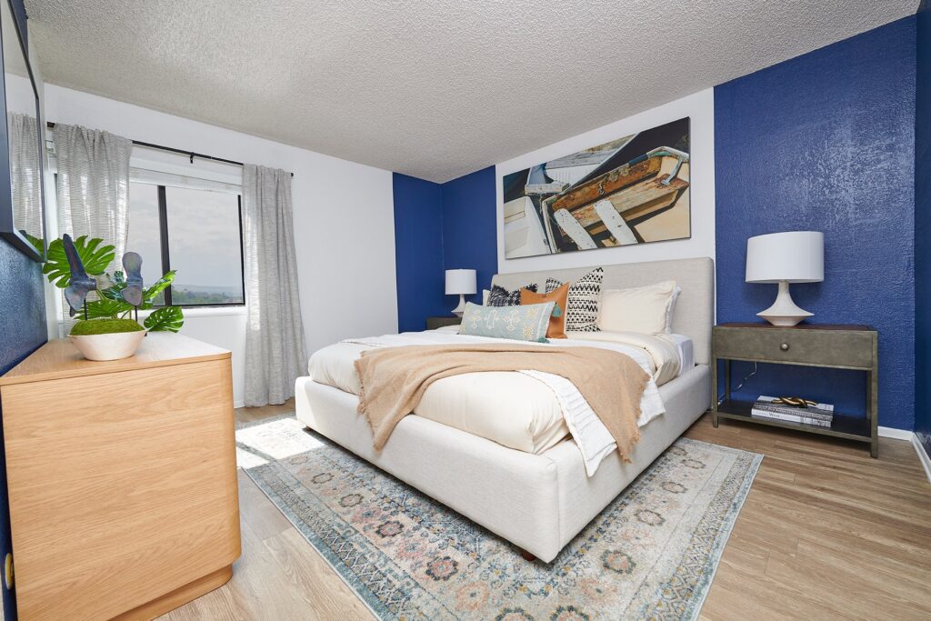 staged bedroom with large window and blue accent wall