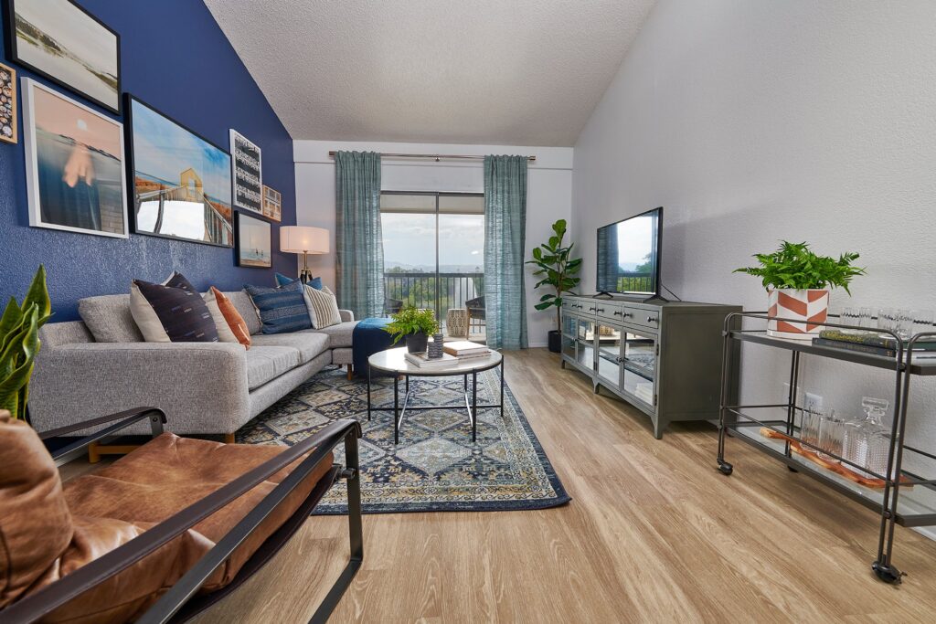 Open living space with blue accent wall and glass doors to patio
