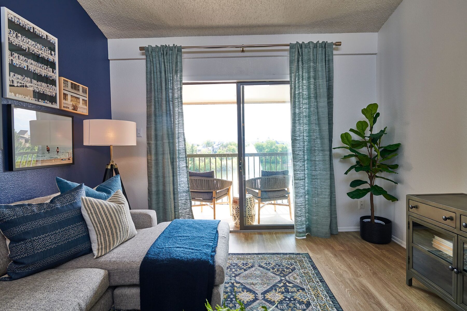 Open living space with blue accent wall and glass doors to patio