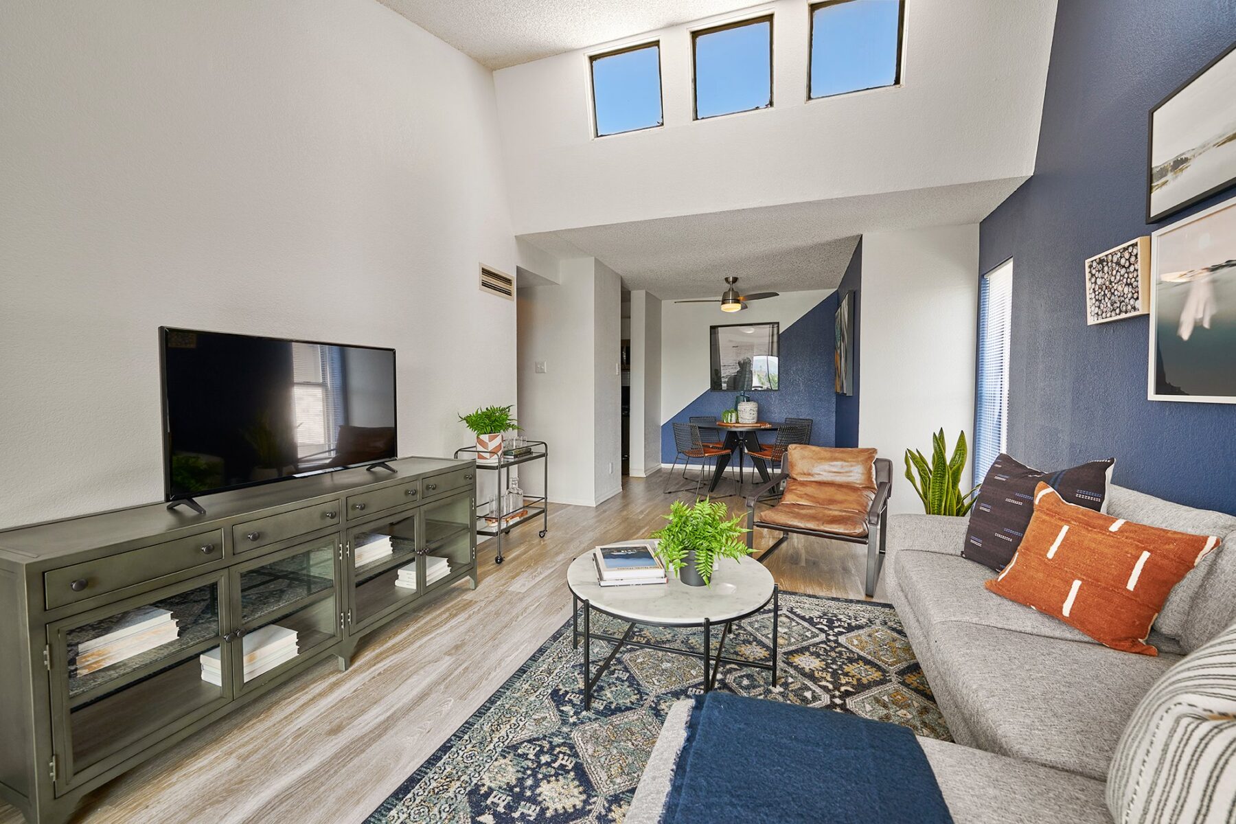 Open Living room with blue accent wall and skylights