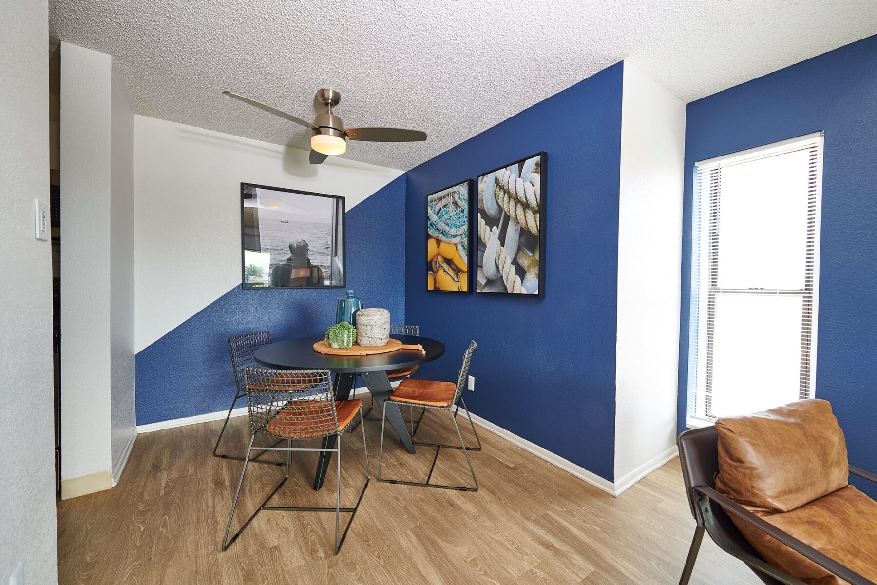 Dining nook with ceiling fan and large window